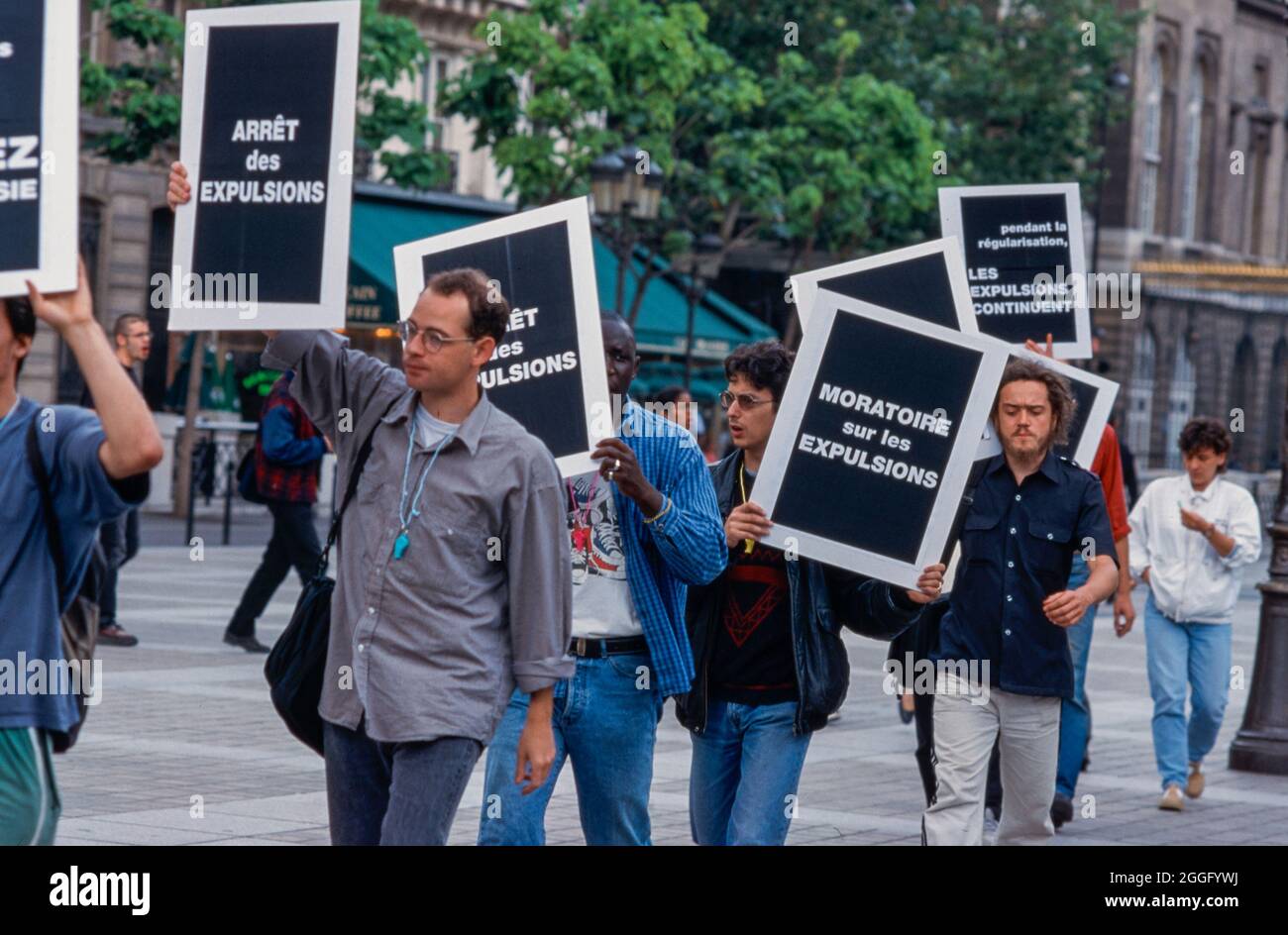 Act Up Paris Group AIDS Activists, Picketing holding Protest Signs, Demonstration against PLWHIV/ Migrant Expulsions, Prefecture de Paris, young activism, anti discrimination Stock Photo
