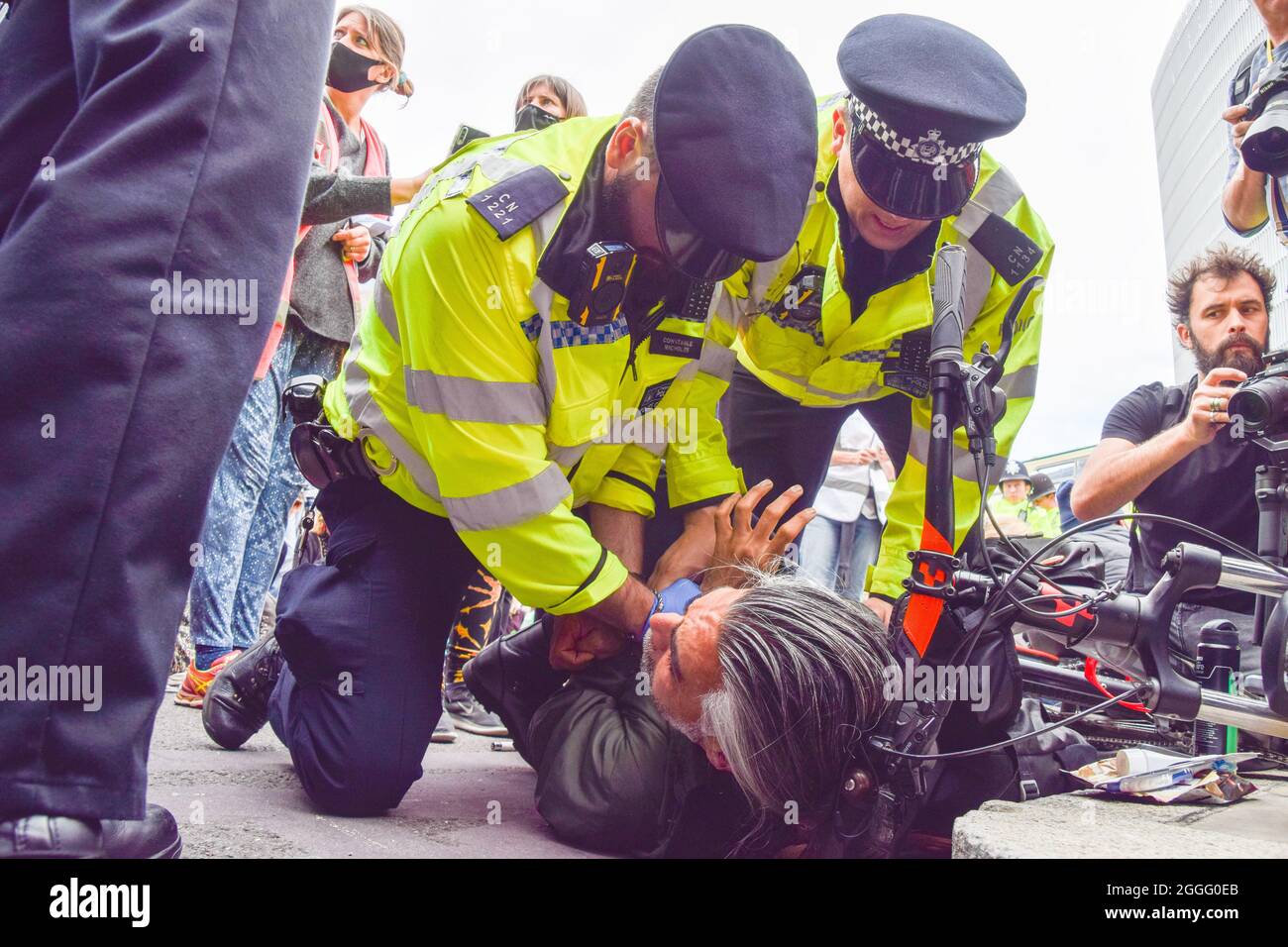 London, United Kingdom. 31st August 2021. Police officers restrain and search a protester. Extinction Rebellion protesters blocked the streets next to London Bridge with a bus, as part of their two-week Impossible Rebellion campaign. (Credit: Vuk Valcic / Alamy Live News) Stock Photo