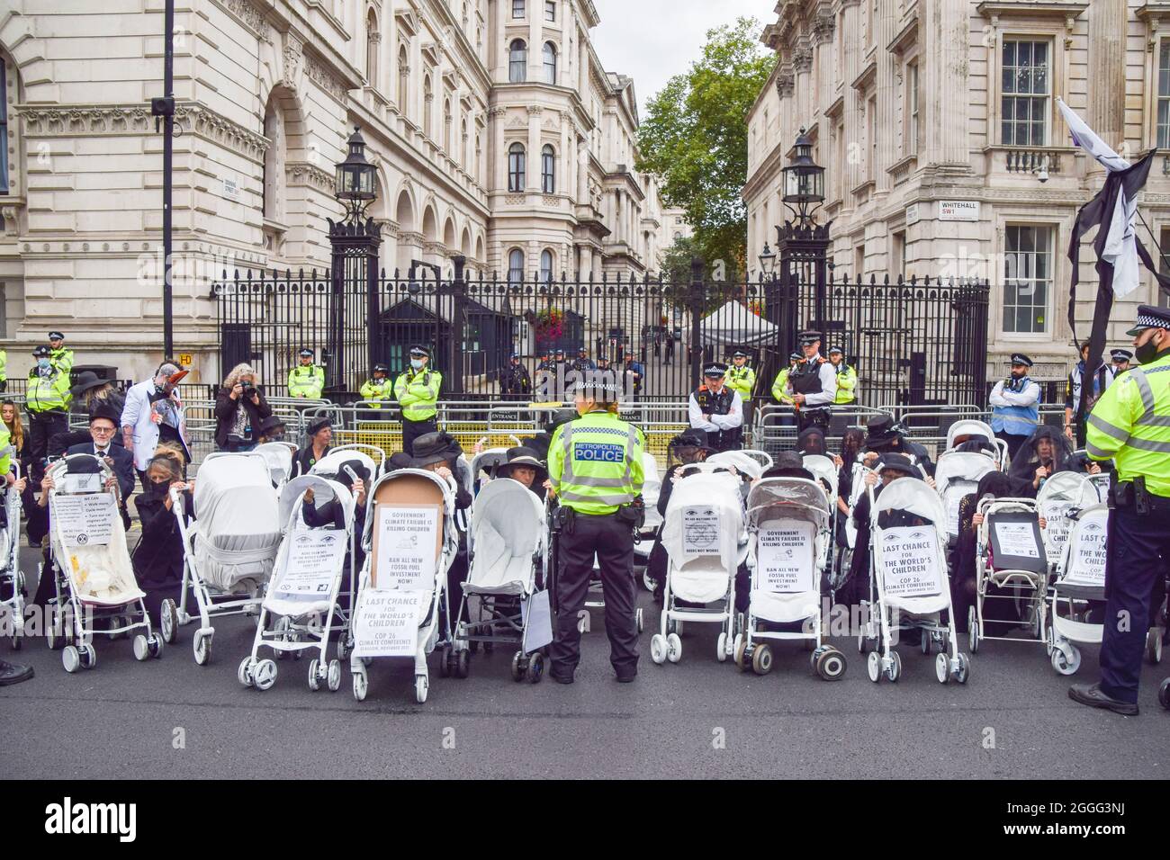 London, UK. 31st Aug, 2021. Protesters attach themselves to prams outside Downing Street during the Pram Rebellion.Extinction Rebellion protesters dressed in black marched with prams in Westminster as part of their two-week Impossible Rebellion campaign, calling on the UK Government to act meaningfully on the climate and ecological crisis. Credit: SOPA Images Limited/Alamy Live News Stock Photo