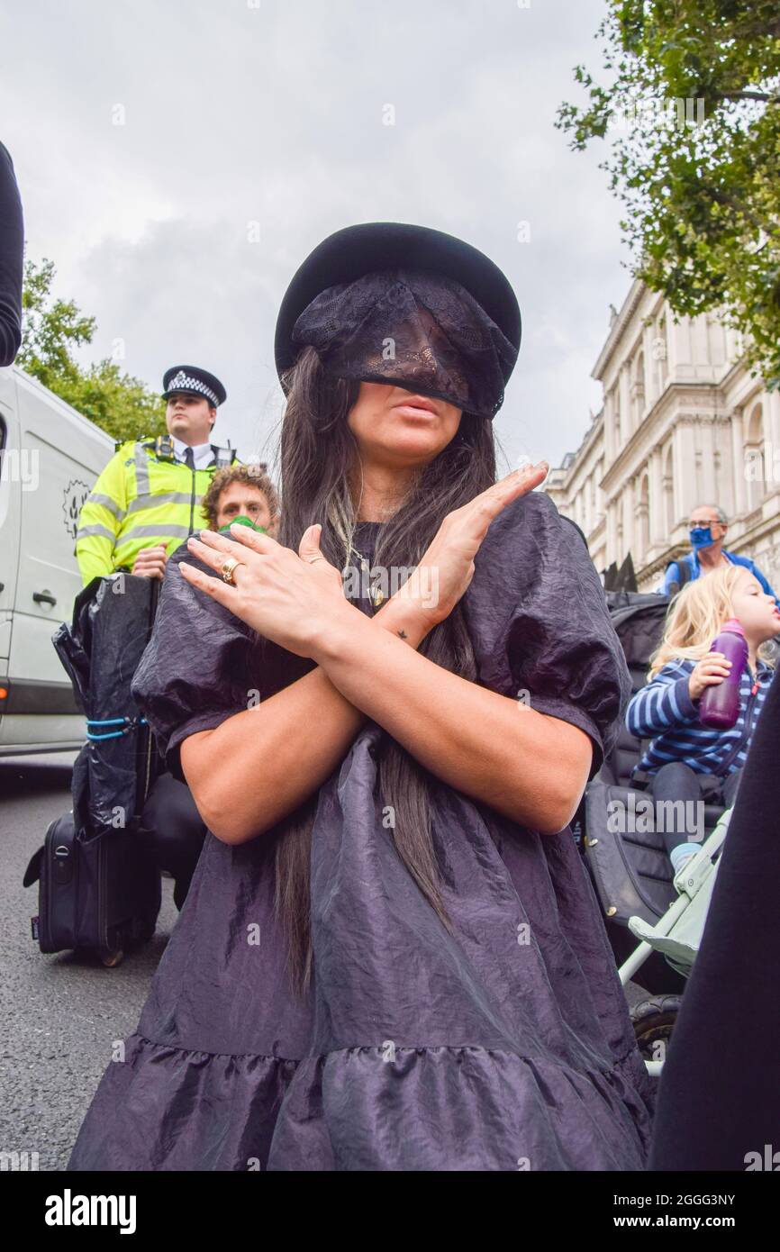 London, UK. 31st Aug, 2021. A protester dressed in black forms an 'X' with her arms during the Pram Rebellion.Extinction Rebellion protesters dressed in black marched with prams in Westminster as part of their two-week Impossible Rebellion campaign, calling on the UK Government to act meaningfully on the climate and ecological crisis. Credit: SOPA Images Limited/Alamy Live News Stock Photo