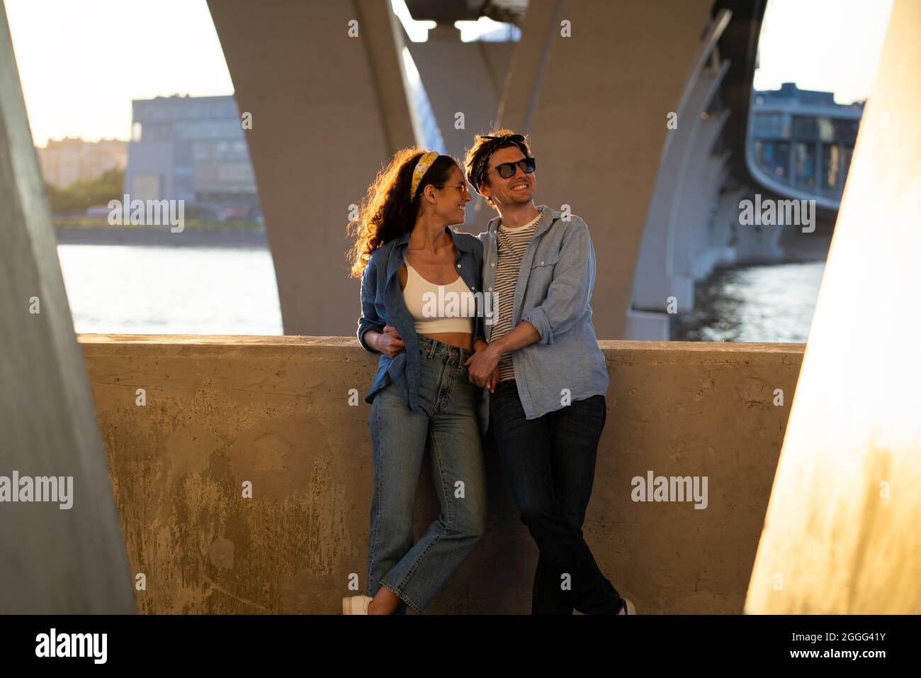 Loving young couple embracing at sunset. Trendy casual man and woman enjoy spending time together Stock Photo