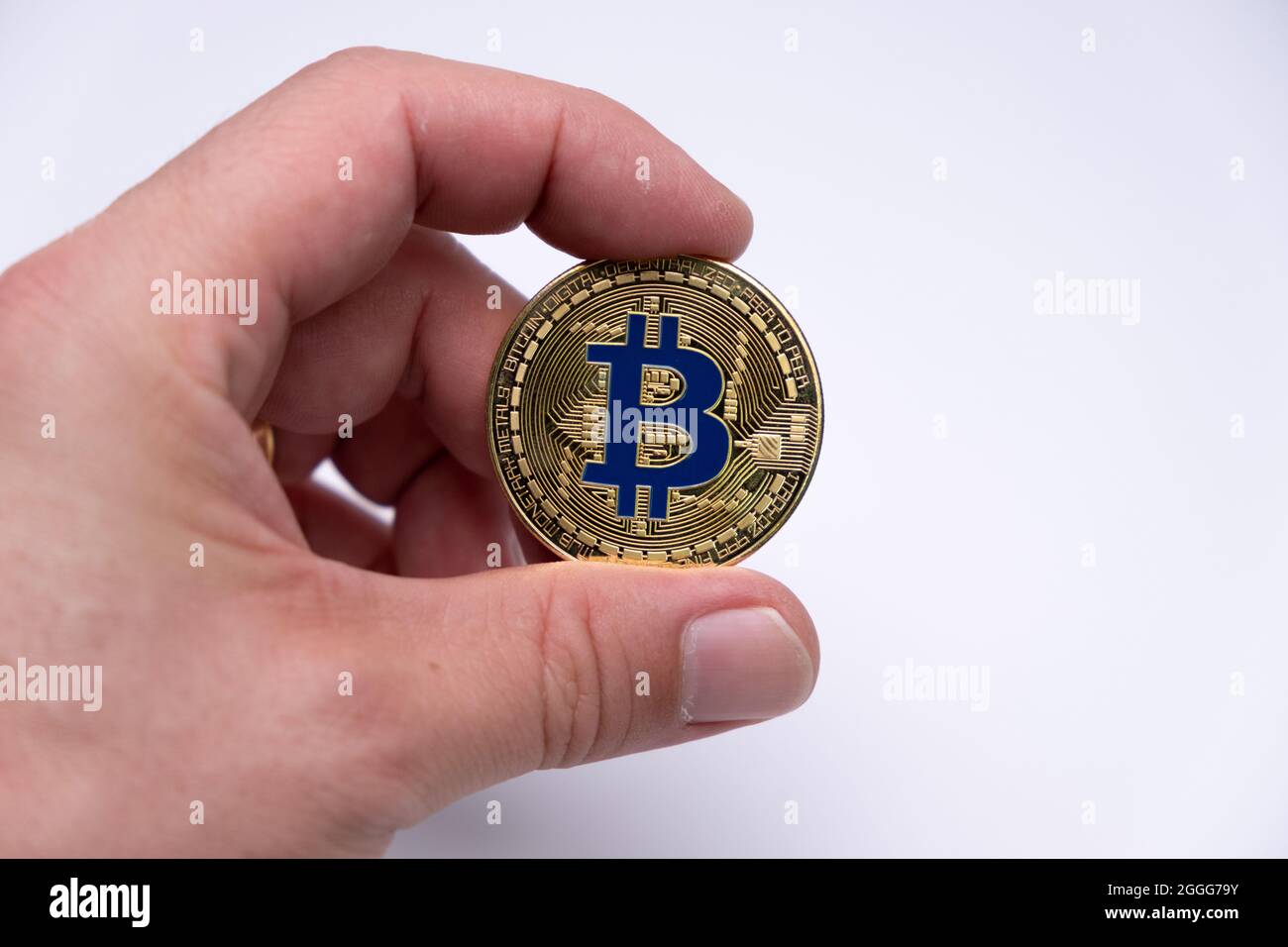 Men Hand fingers holding bitcoin coin crypto currency - BTC electronic virtual money for web banking and international network payment. Stock Photo