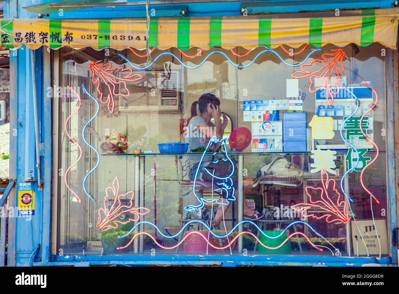 Glass kiosk at side of highway selling betel nut leaf from betel nut beauty (binlang girl), Caotun, Taiwan Stock Photo