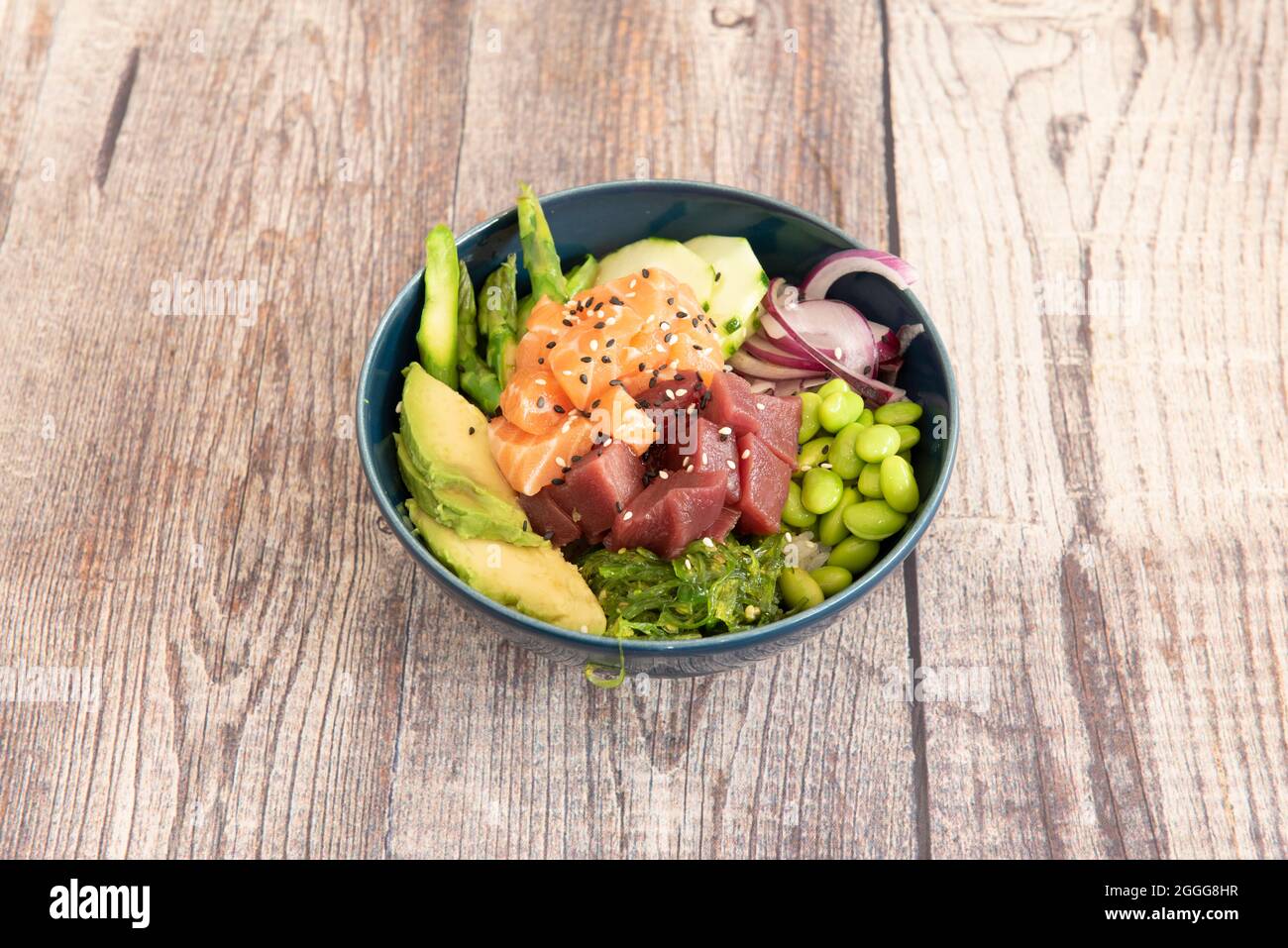 Blue porcelain bowl filled with red tuna, marinated salmon, red onion