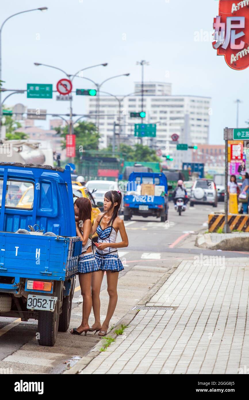Two betel nut beauties (binlang girl) selling betel nut leaf to truck driver at side of highway, Taipei, Taiwan Stock Photo