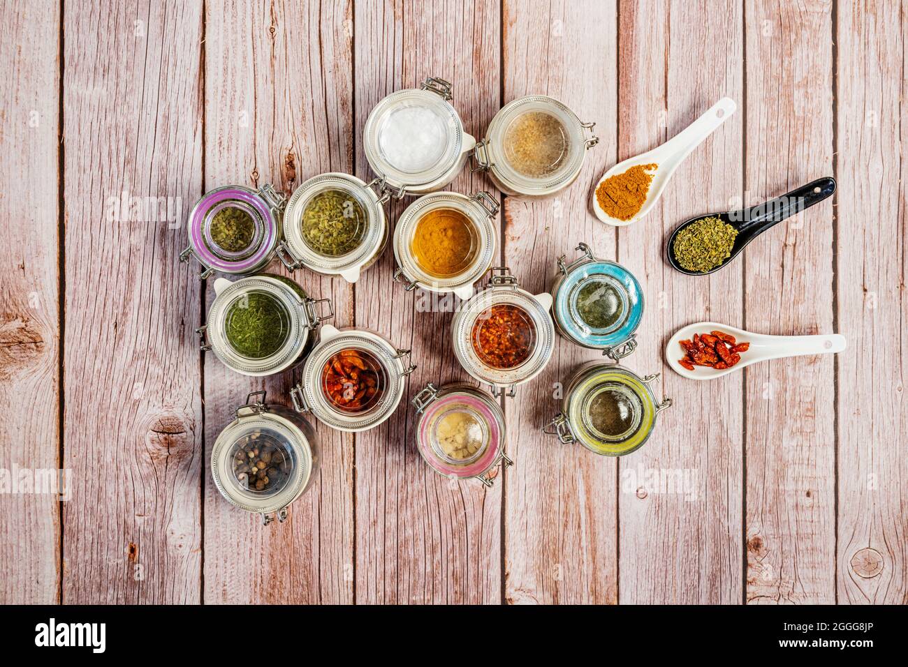 Glass spice jars with peppercorns, paprika powder, yellow curry
