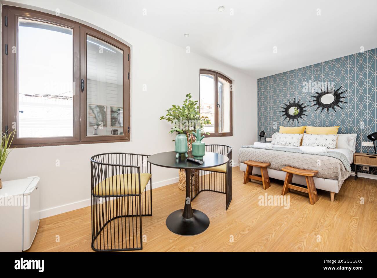 Small studio with king size bed and black multipurpose table in a ...