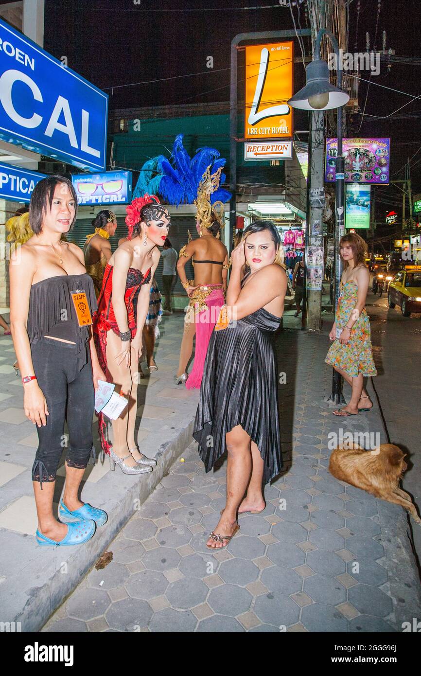 Thai ladyboys stand on street attracting customers before performing cabaret on stage, Phuket, Thailand Stock Photo