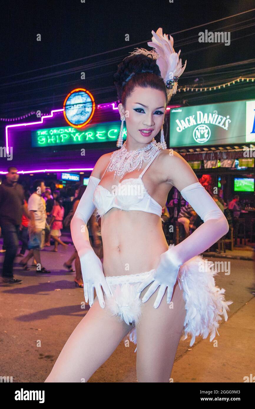 Thai ladyboy cabaret performer dressed all in white with headdress, long gloves and underwear outside club, Phuket, Thailand Stock Photo