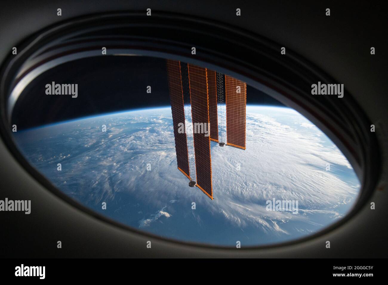A view of Earth from SpaceX Crew Dragon Endeavour with ISS solar arrays in the foreground. Stock Photo