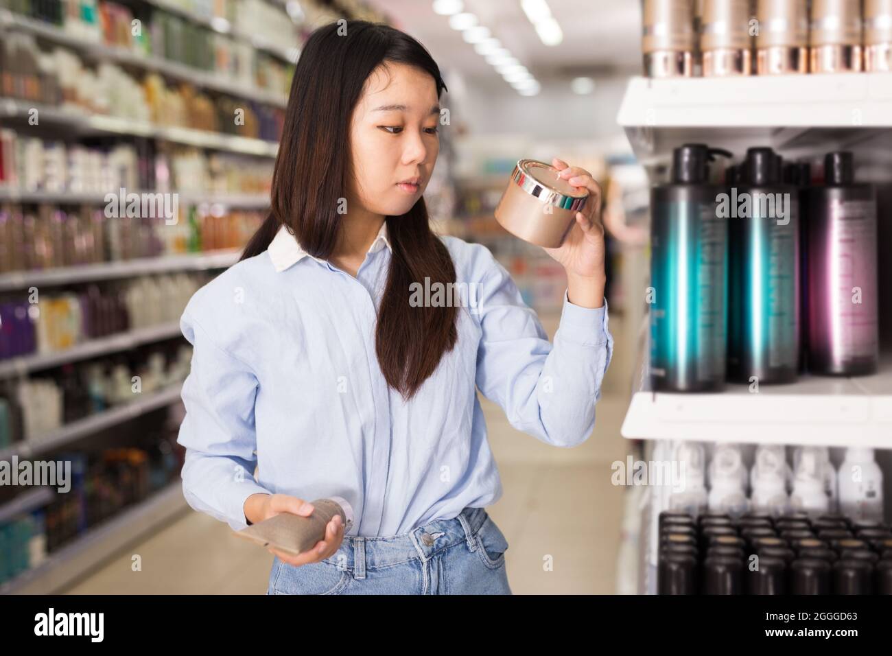 Asian female selecting hair conditioner Stock Photo Alamy