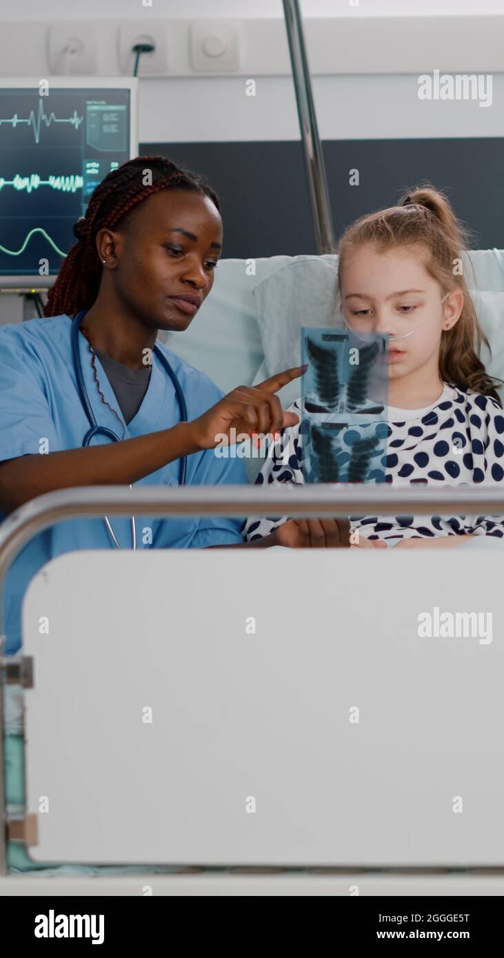 African american nurse showing lungs radiography explaining recovery ...