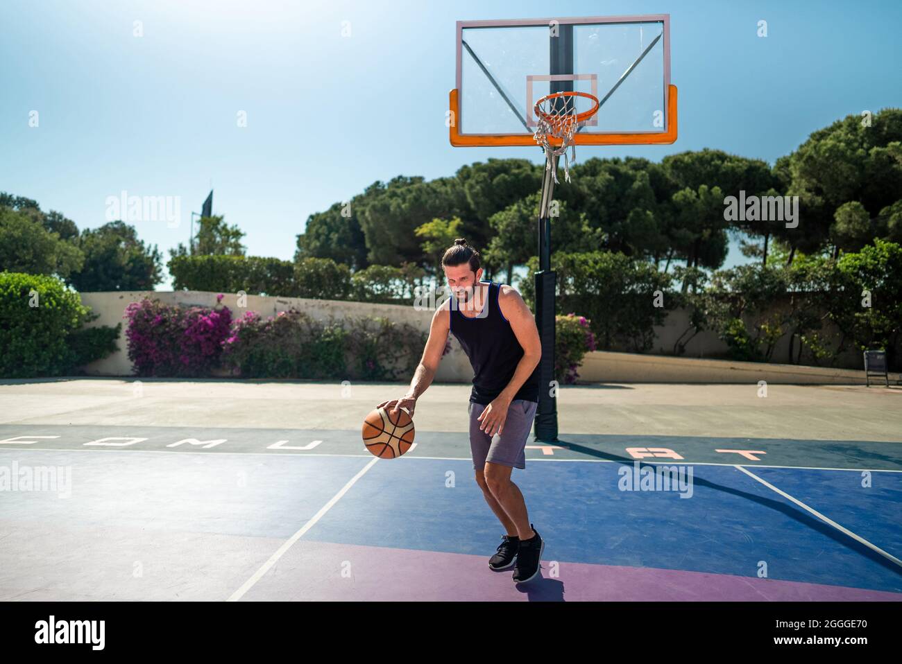 Man basketball player runs on a basketball court with a ball