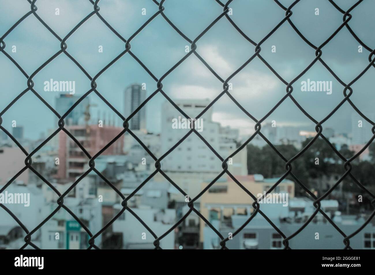 a close-up of the fence from steel mesh with cityscape's background in Ho Chi Minh City, Vietnam Stock Photo