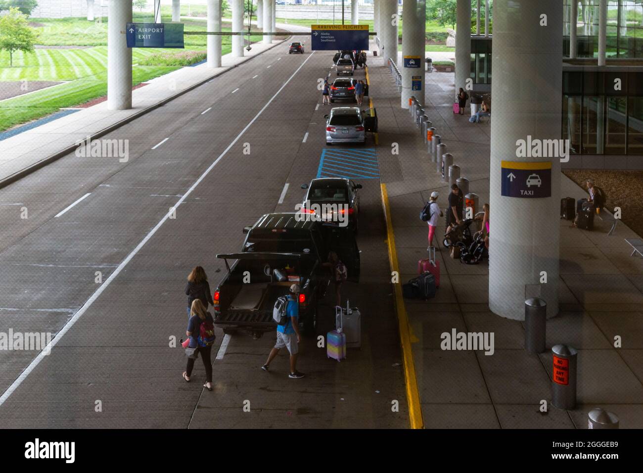 Cars line up to drop off travelers at the terminal entrance at the