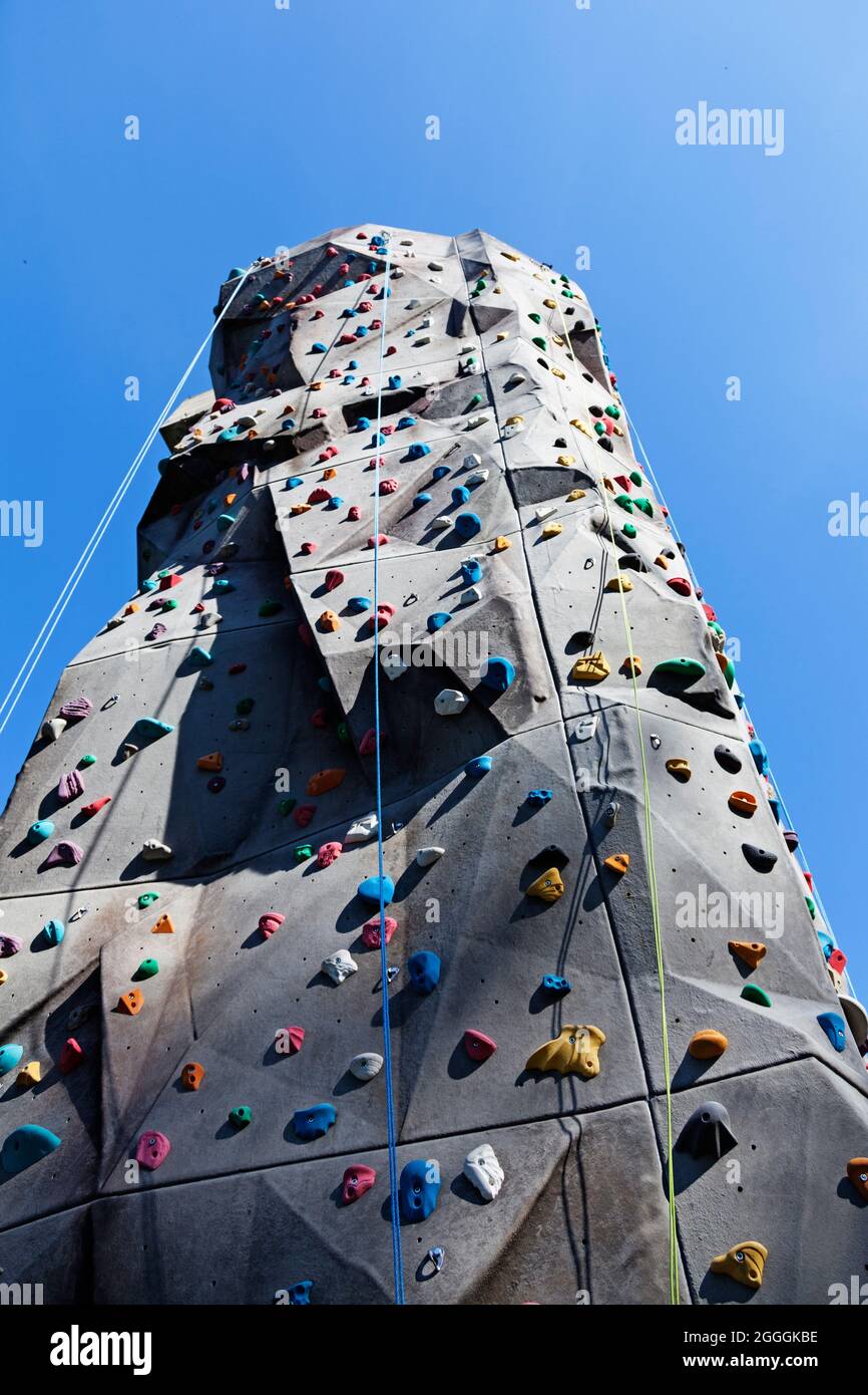 high climbing wall with ropes and various ledges Stock Photo Alamy