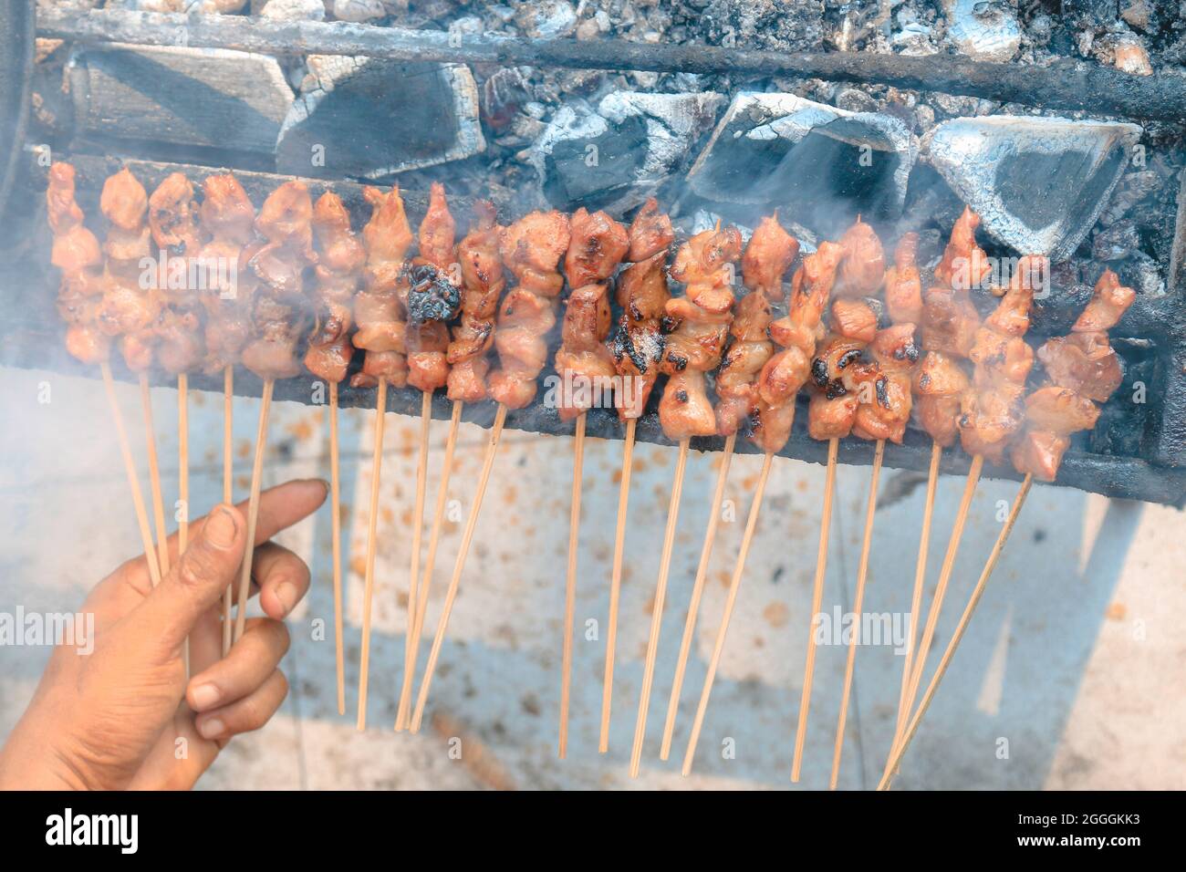 Top view of Sate Kambing or goat satay on red fire grilling by people. Stock Photo