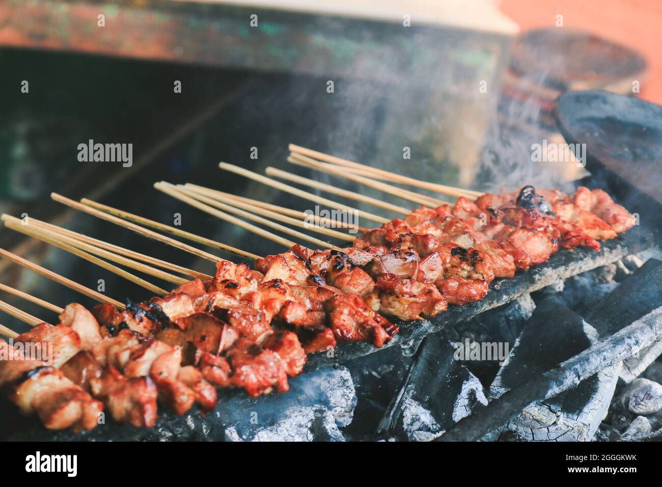 Sate Kambing or goat satay on red fire grilling by people. Stock Photo