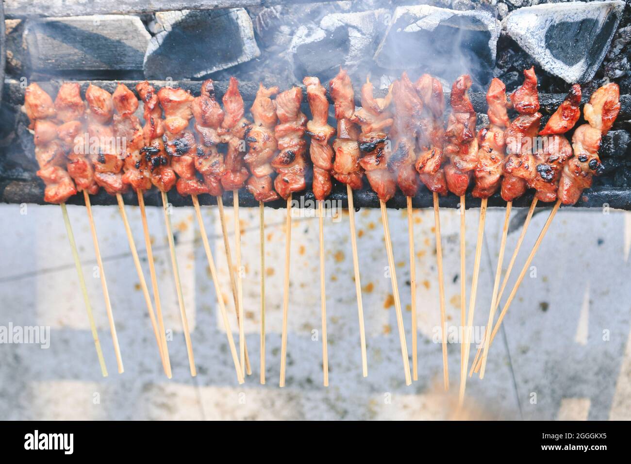 Top view of Sate Kambing or goat satay on red fire grilling by people. Stock Photo