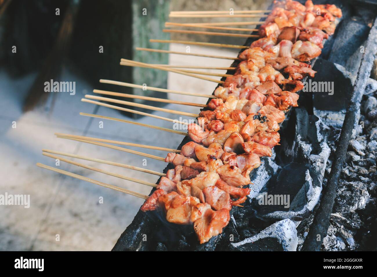 Sate Kambing or goat satay on red fire grilling by people. Stock Photo