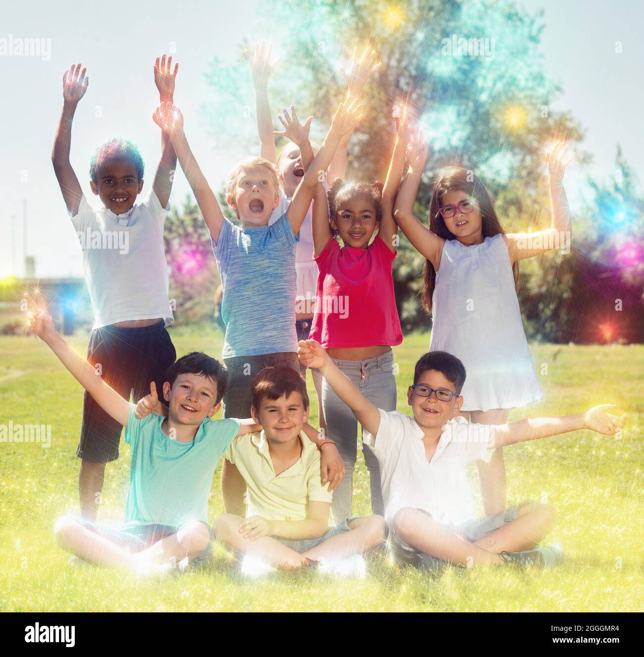 Happy children holding hands up and smiling together in park Stock ...