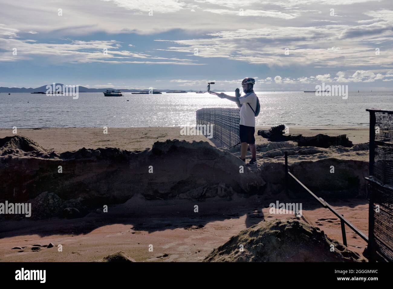 Vlogger recording outside on the beach at sundown. Video blogger at work Stock Photo