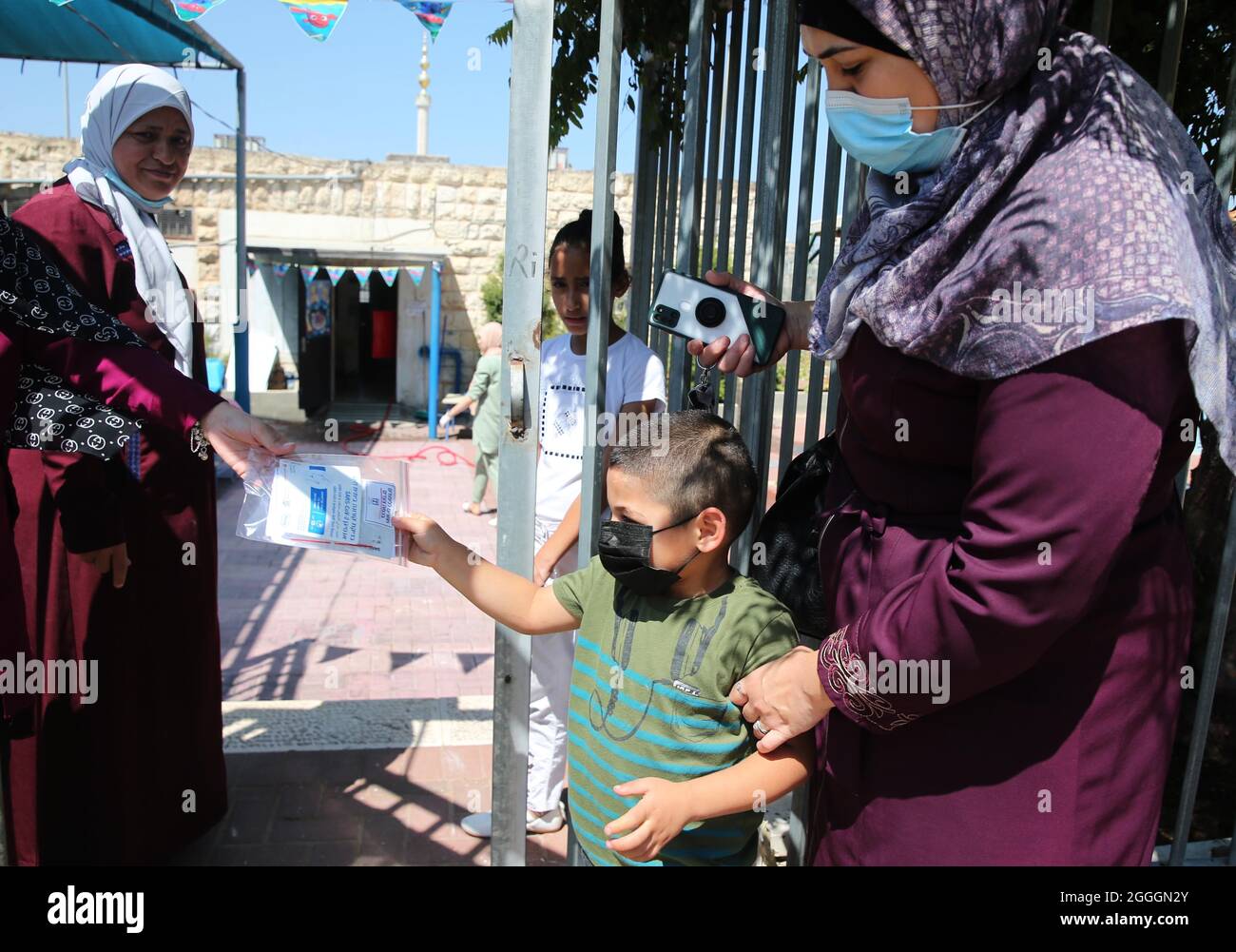 Jerusalem. 31st Aug, 2021. A teacher hands a SARS CoV-2 Antigen self-test kit to a child at a school in Jerusalem, on Aug. 31, 2021. Israel started a national COVID-19 test campaign among kids from 3 to 12 years old in order to safely reopen the schools on Sept. 1. Credit: Muammar Awad/Xinhua/Alamy Live News Stock Photo