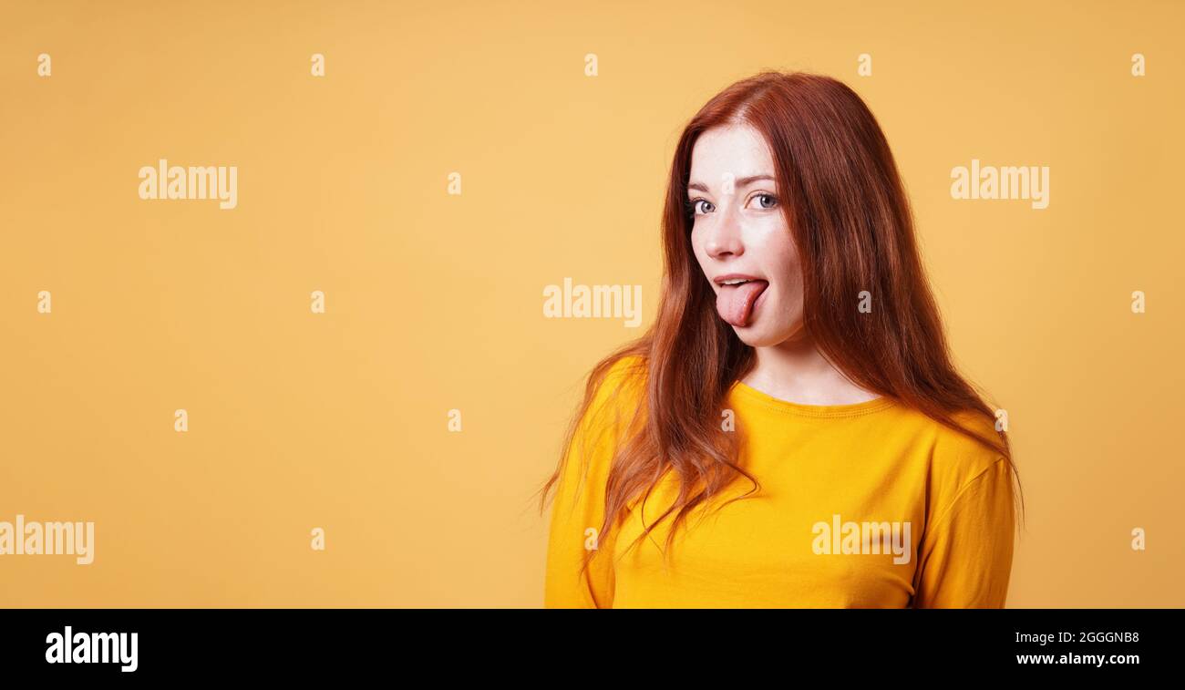 cheeky young woman sticking out her tongue Stock Photo