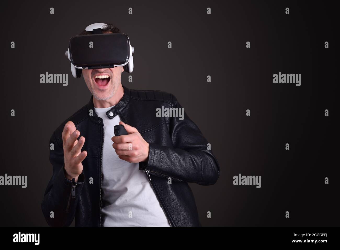Man having fun dressed casual playing with virtual reality glasses with black isolated background Stock Photo