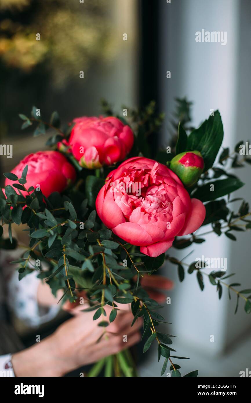 Florist woman collects a bouquet of pink peony roses. Small business ...