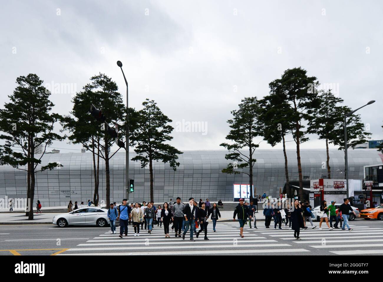 Pedestrians crossing the road in front of the The iconic Dongdaemun Design Plaza in Seoul, Korea. Stock Photo