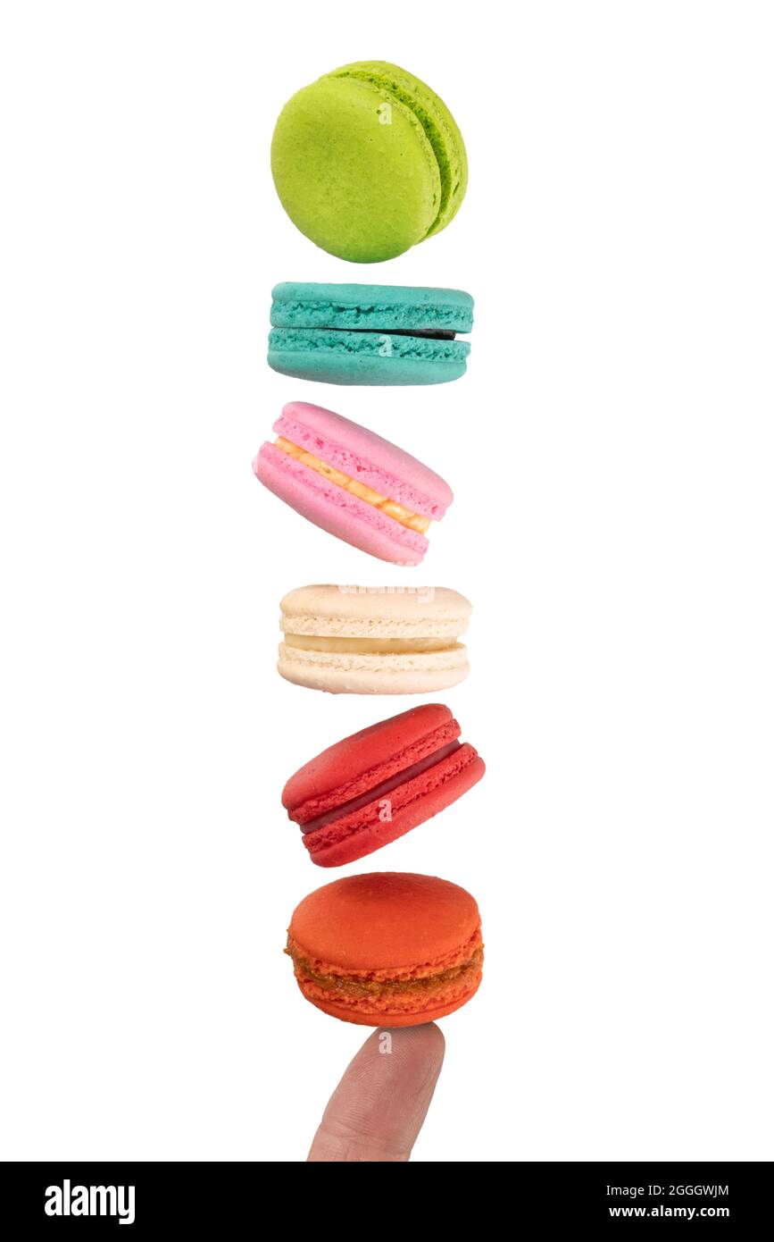 Colorful macaroons levitating on a finger. Levitation food photography concept. Stock Photo