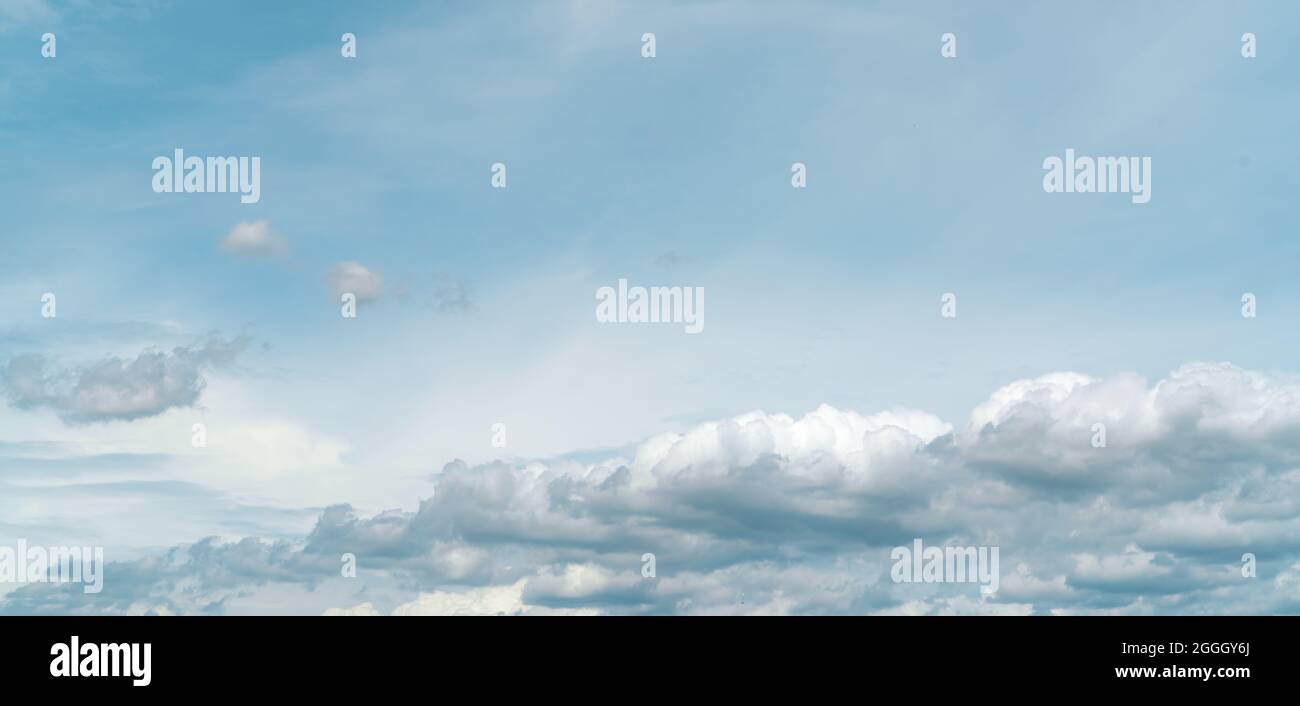 Panorama view of white fluffy clouds on blue sky. Close-up white cumulus clouds texture background. White puffy cloudscape. Beauty in nature. Stock Photo