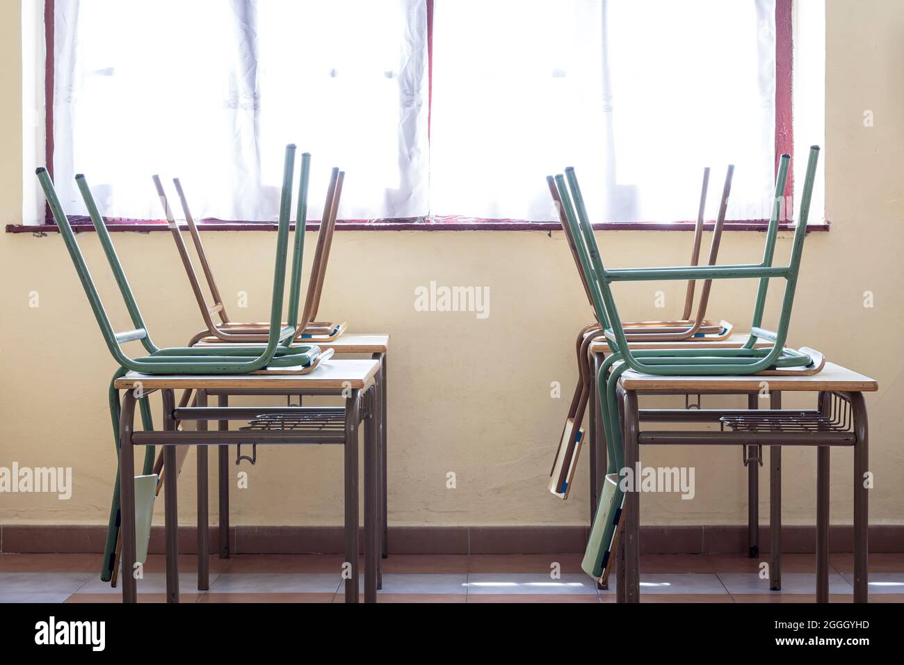 Photograph of children's chairs on the desks of a nursery school.The photo is taken in horizontal format. Stock Photo