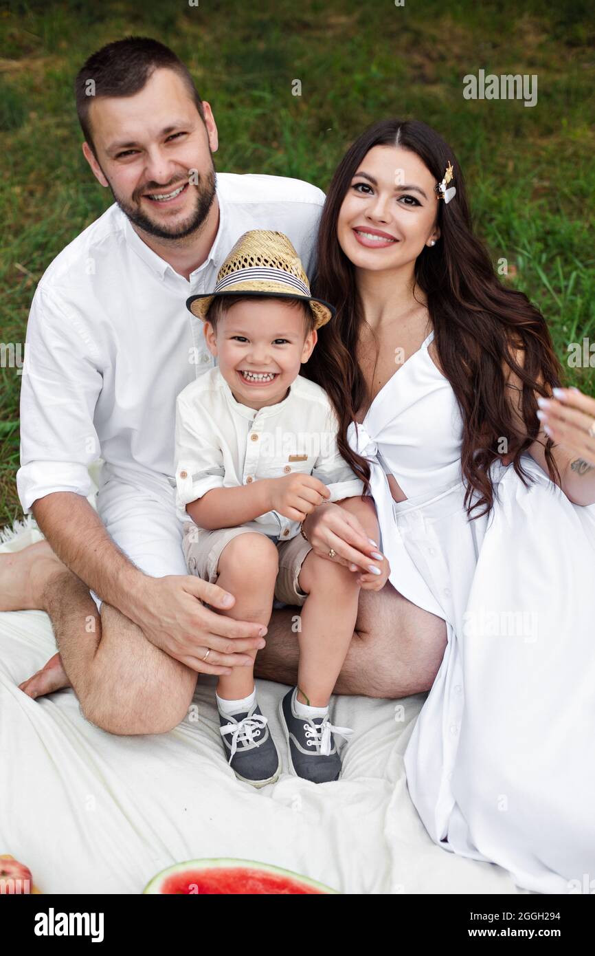 Beautiful mum, dad and their cute little child have fun together and ...