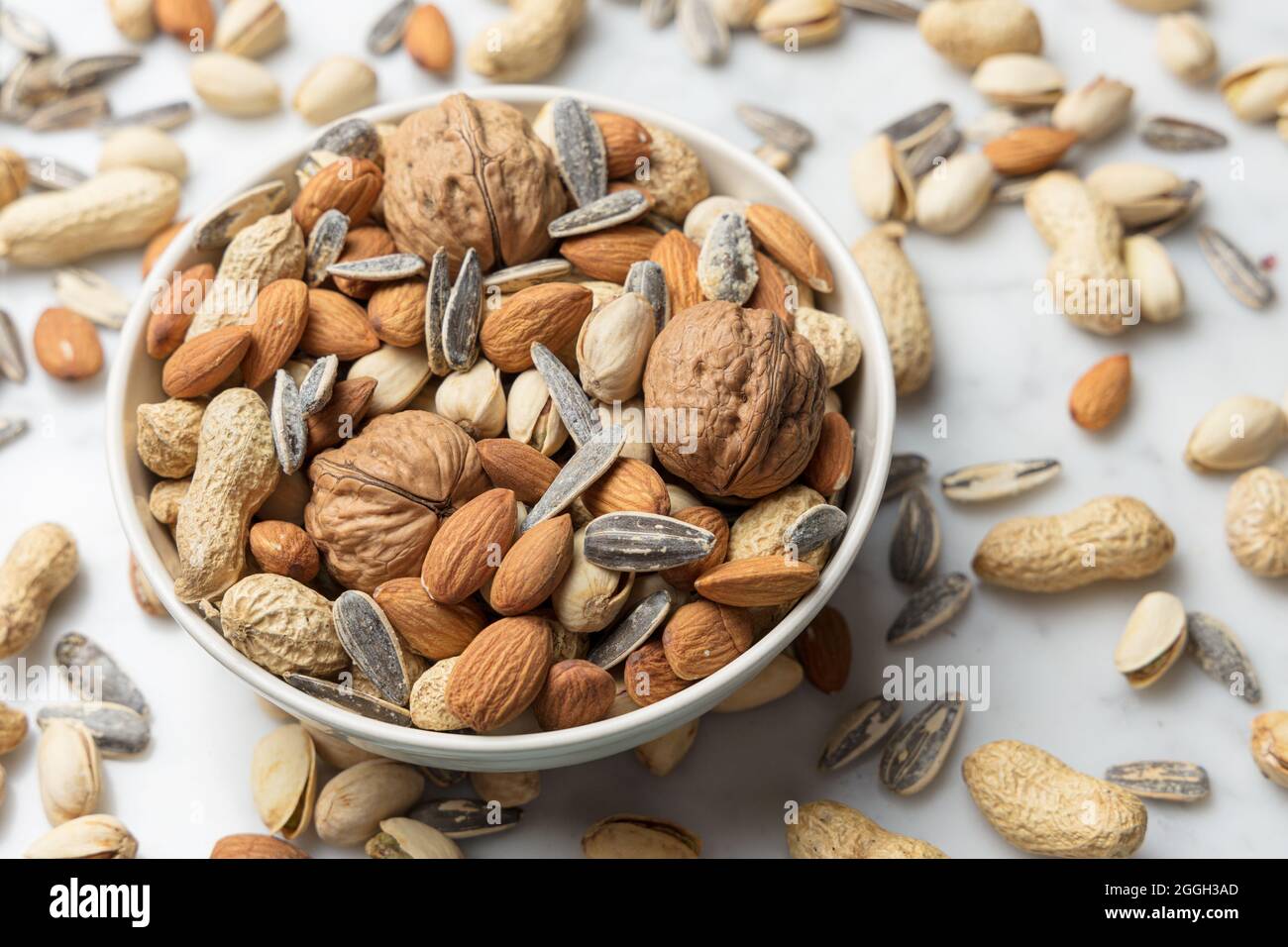 Heap of mixed nuts in a bowl almond, walnut, peanut, pistachio and