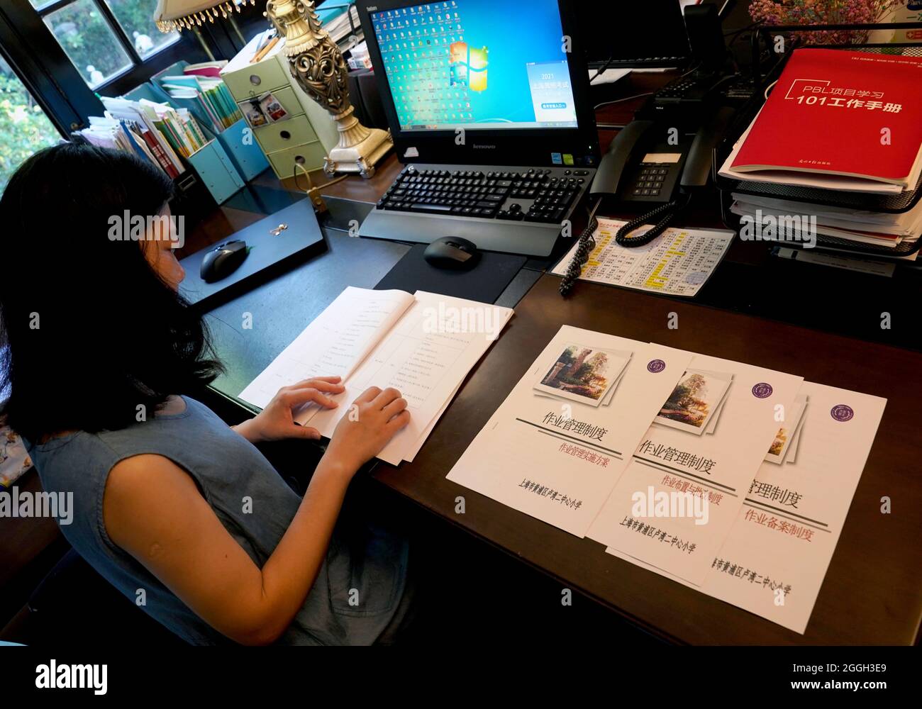Shanghai. 1st Sep, 2021. A teacher views the new regulation on assigning homework at an elementary school in east China's Shanghai, Sept. 1, 2021. Elementary and middle schools in China kicked off a new school year on Wednesday. Credit: Liu Ying/Xinhua/Alamy Live News Stock Photo