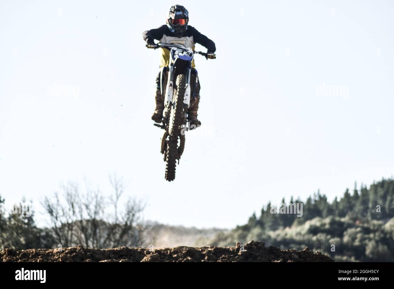 Boy jumping with his bike on a motocross track Stock Photo