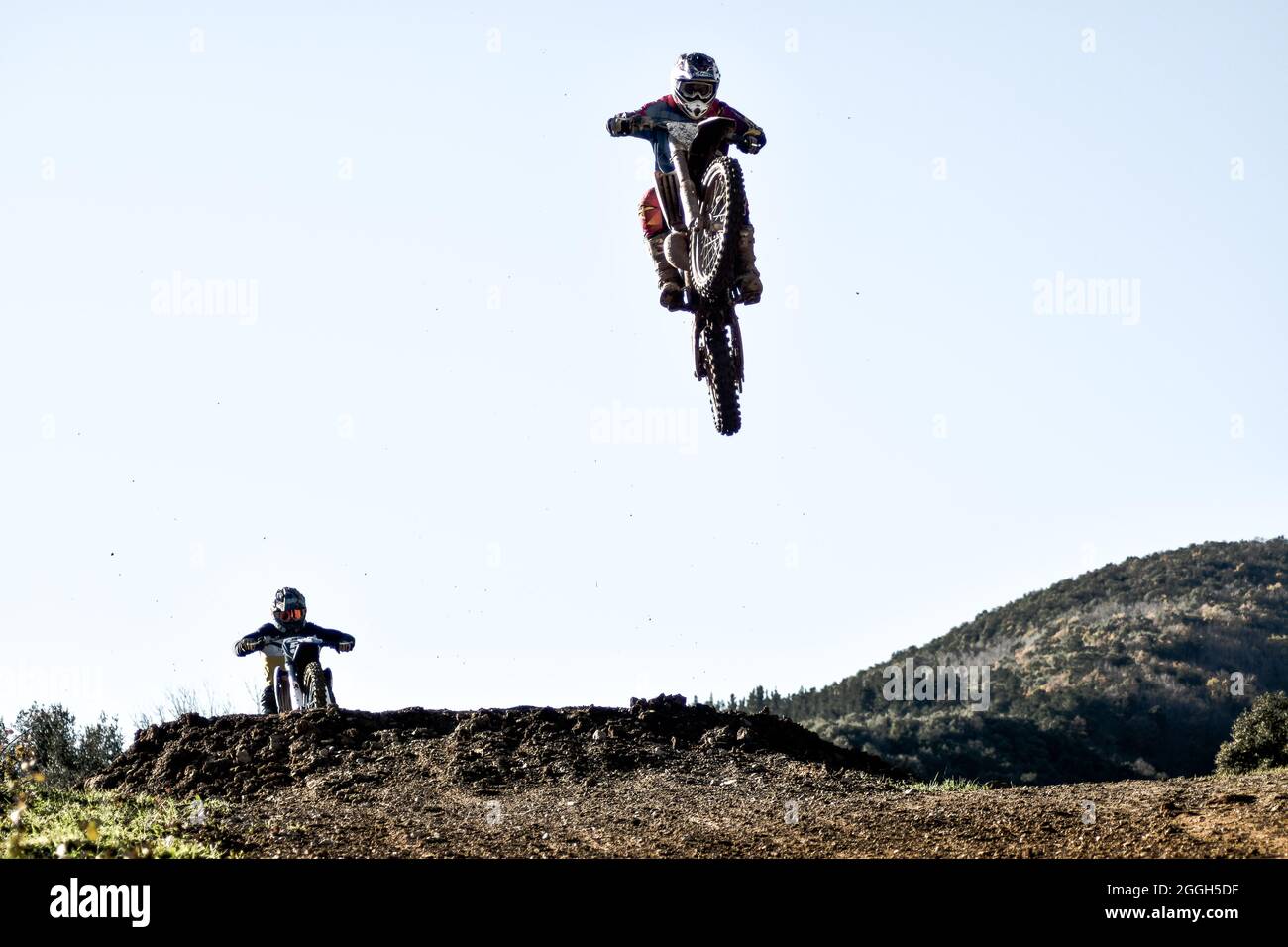 Friends jumping with their bikes on a motocross track 1 Stock Photo