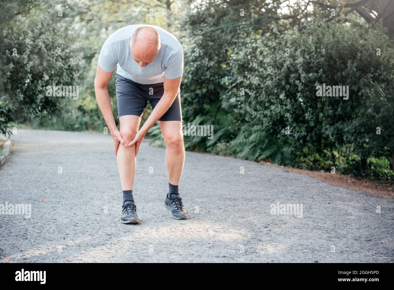 Male runner holding his knee and suffering from runner's knee injury Stock Photo Alamy