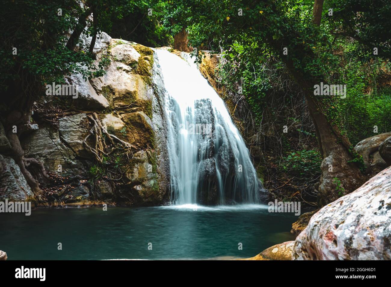 Scenic view of a waterfalls in the middle of a forest Stock Photo - Alamy