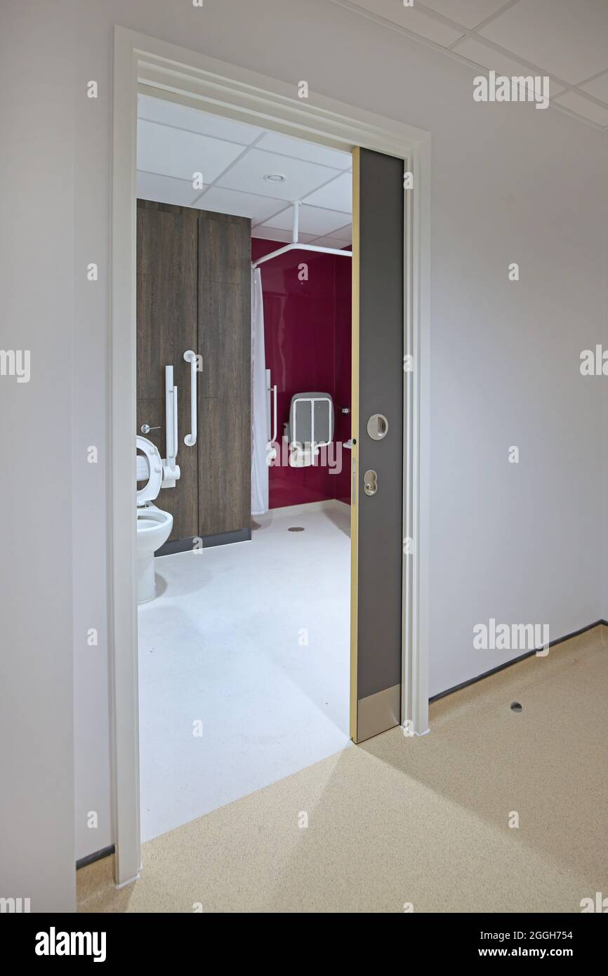 A concealed, sliding 'pocket' door provides access to a disabled toilet in a new London health centre Stock Photo
