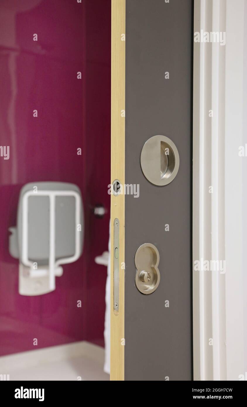 A concealed, sliding 'pocket' door provides access to a disabled toilet in a new London health centre Stock Photo