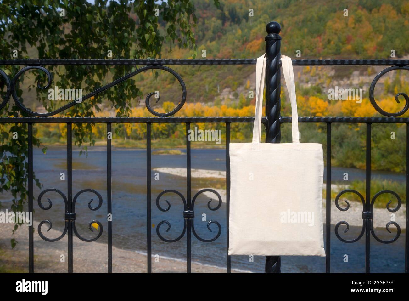 Canvas tote bag on the bridge railing mockup. Rustic linen shopper bag mock up for branding presentation Stock Photo