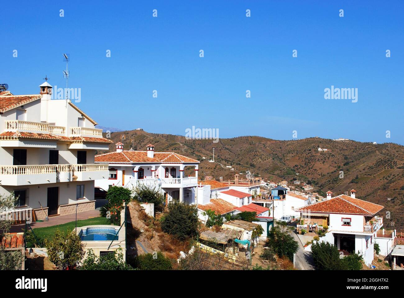 View of the whitewashed village (pueblo blanco) with mountains to the rerar, Moclinejo, Spain. Stock Photo