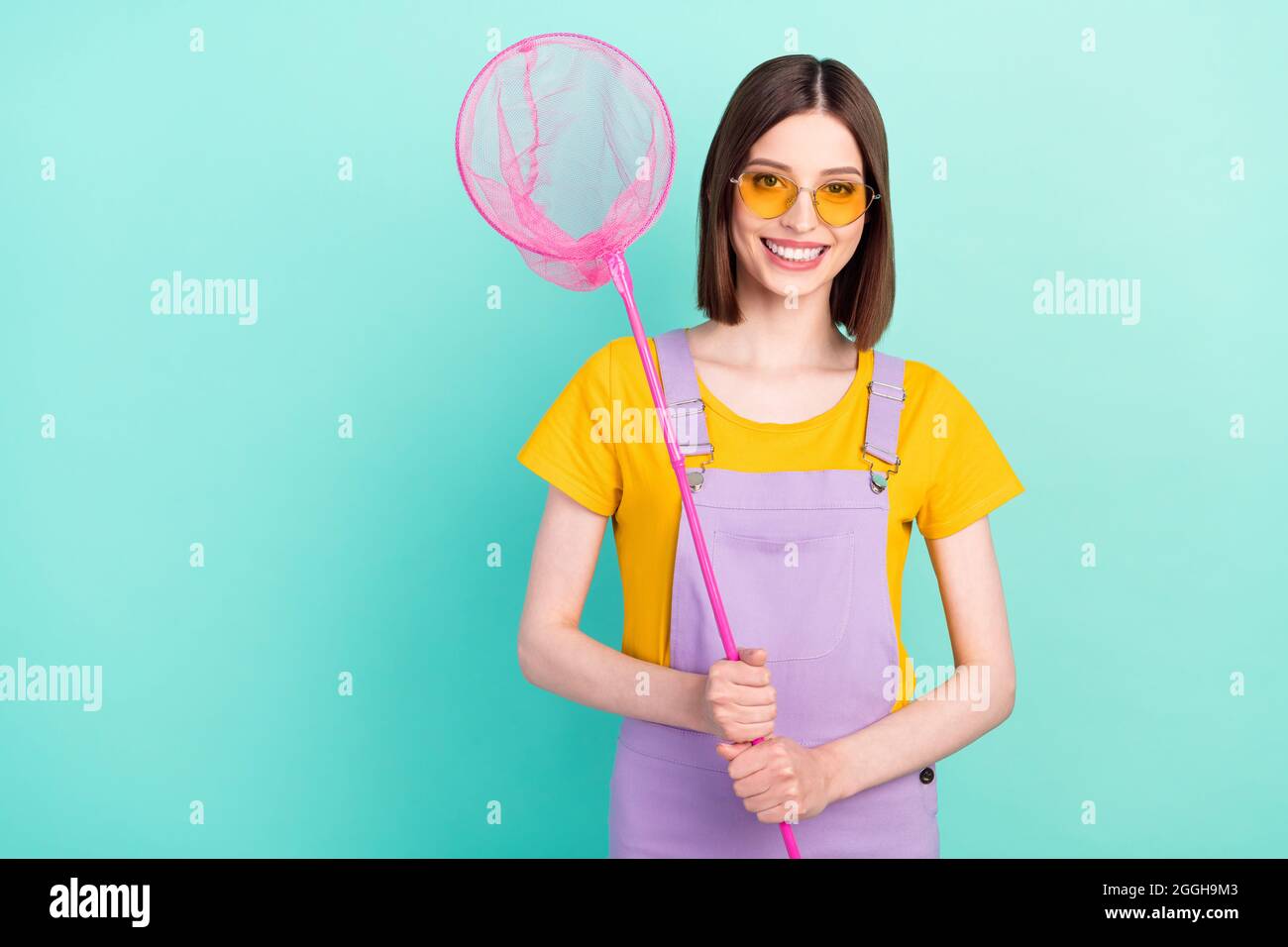 Photo of cheerful young happy positive woman hold hands net catcher smile isolated on pastel teal color background Stock Photo