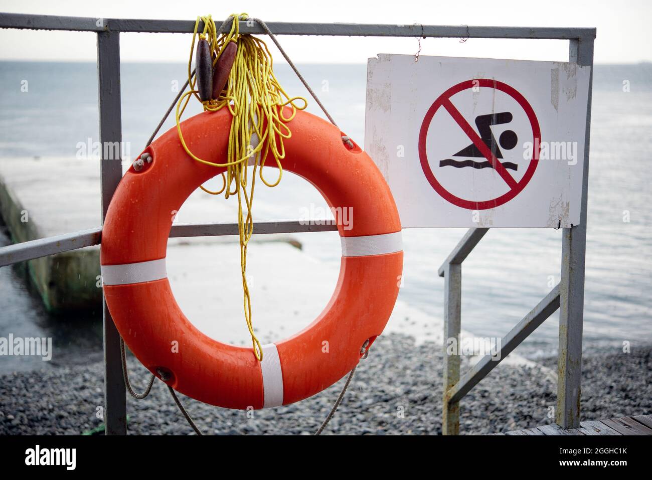 No swimming sign and orange lifebuoy at the beach during the storm Stock Photo