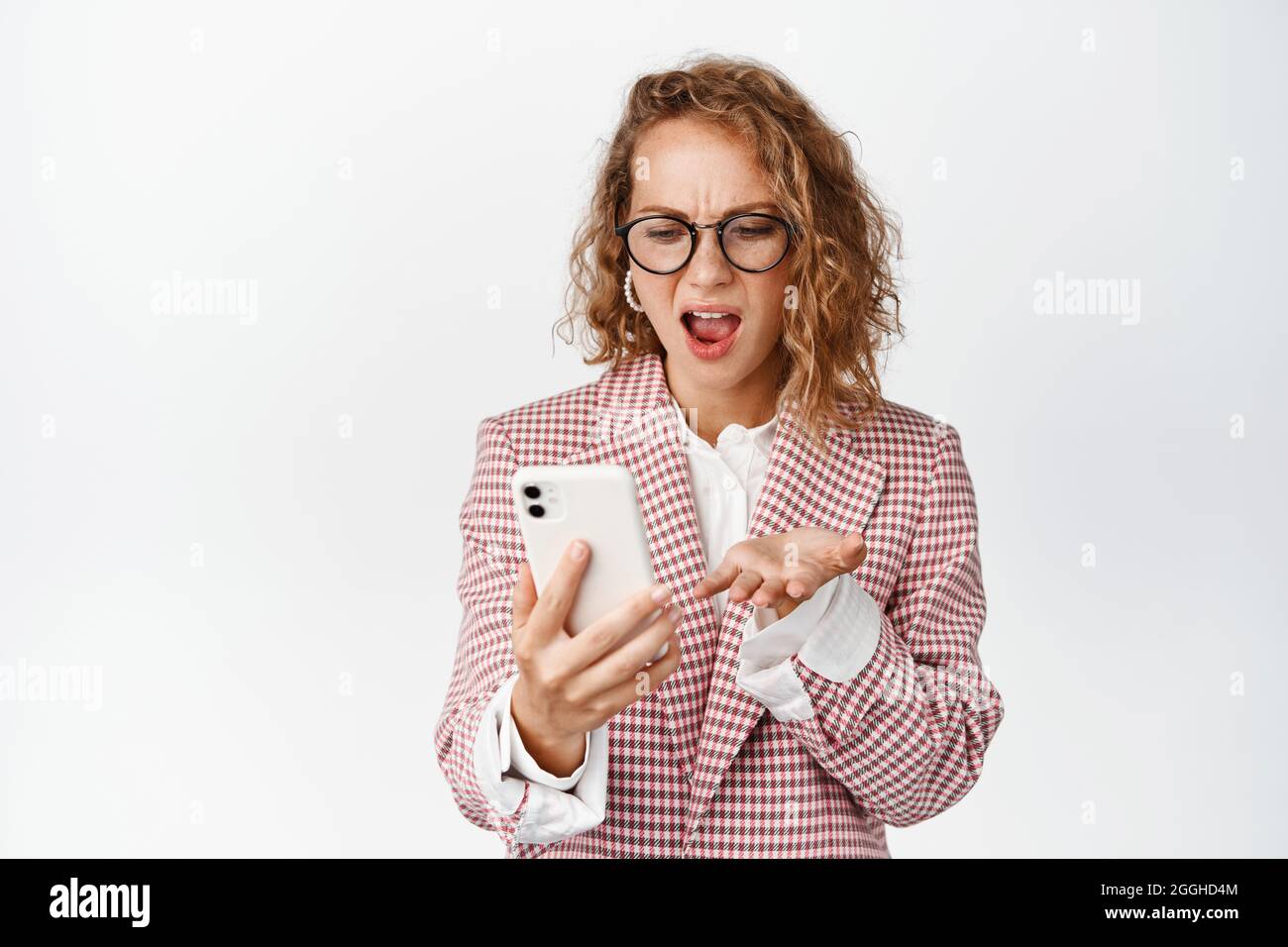 Angry corporate woman, lady boss looking at mobile phone and screaming ...