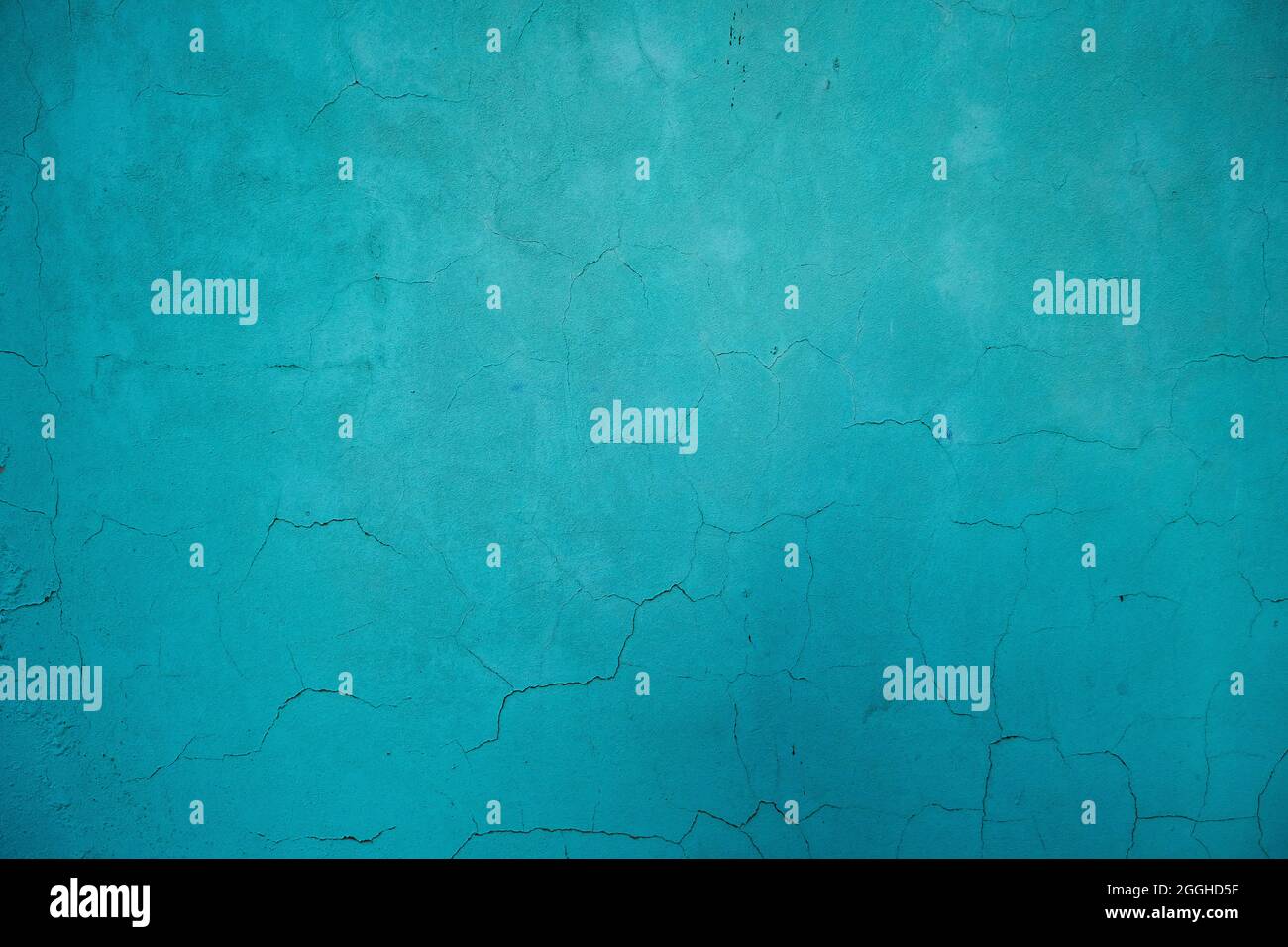 Turquoise colored wall with damp and cracking plaster Stock Photo
