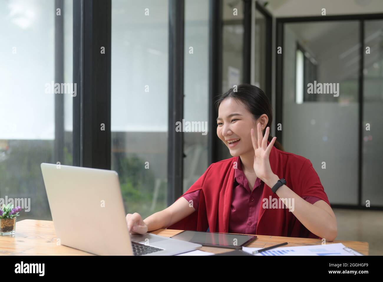 Young Asian woman making video call with her friends on laptop computer ...